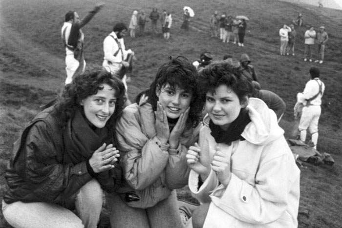 Three girls wash their face in the morning dew at the top of Arthur's Seat